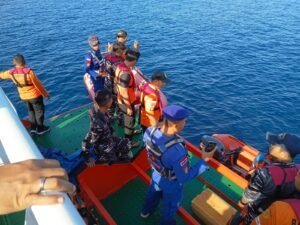 Search and rescue teams on a boat deck in Maumere Bay