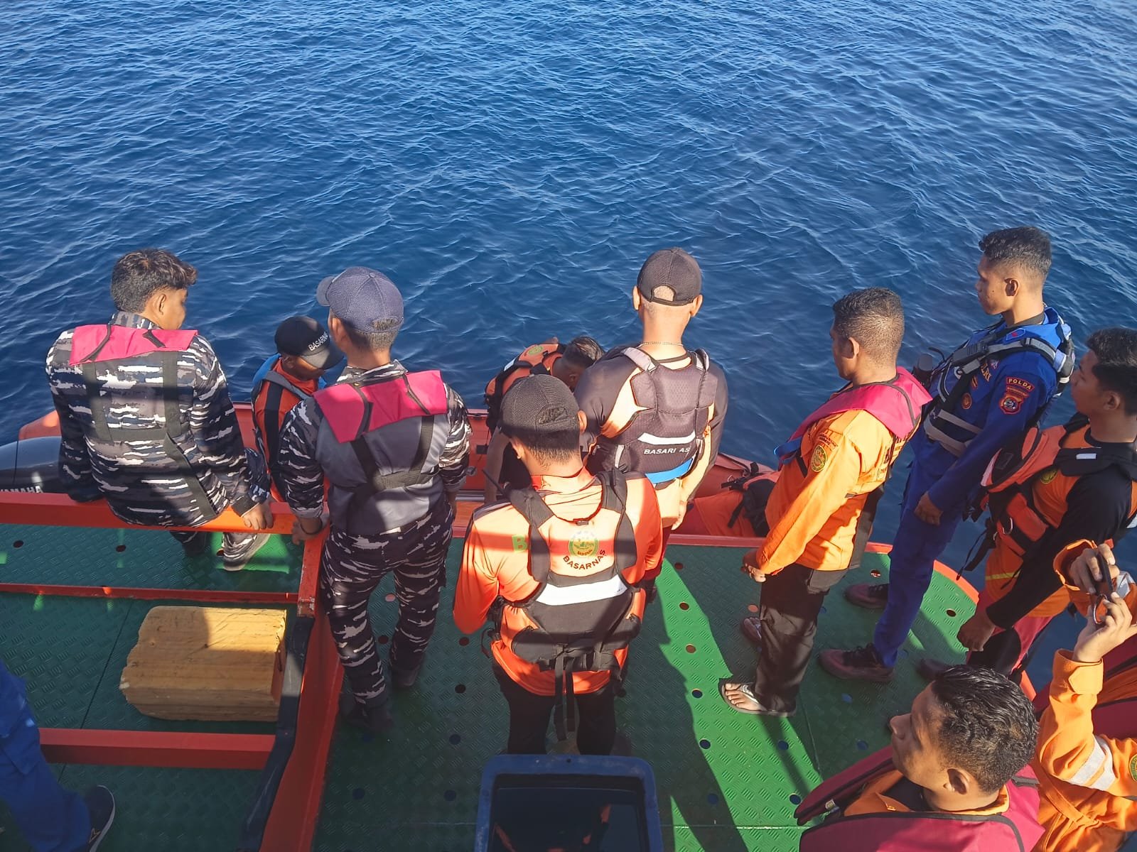 Search and rescue personnel gathered beside an inflatable boat in Maumere Bay